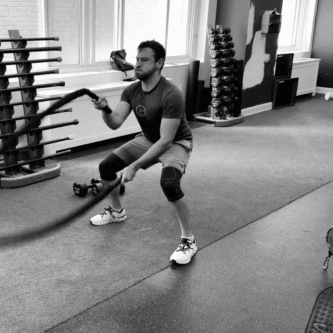 Client mid-set on battle ropes during a Density Method session
